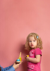 Fototapeta premium Portrait of little girl of 2-3 years on speech therapy.Concept over pink background
