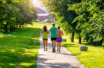 A man and girls go for a run in the city Park
