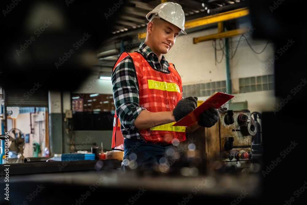 Poster manufacturing worker working with clipboard to do job procedure checklist . factory production line 