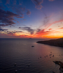 Aerial drone shot of sunset burning sky clouds on Komiza town over Vis Island in Croatia Summer