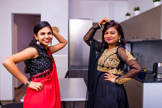 happy indian sisters are dancing together in new light apartment with design repair moving concept house