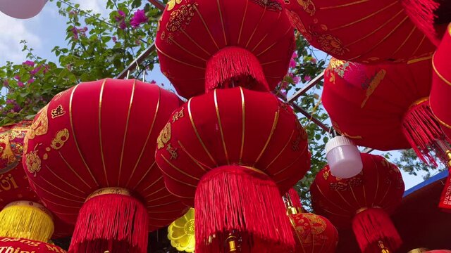 Slowmotion shot of colorful red and golden Chinese lanterns sold on an Asian street market prior to the Tet holiday or Lunar new year in Asia. TET concept. Travel to Asia. Letterings on lanterns and