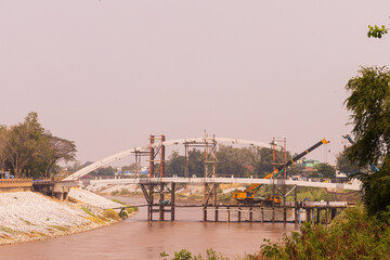 The new bridge between construction structures over the river, crane and truck on time on place 