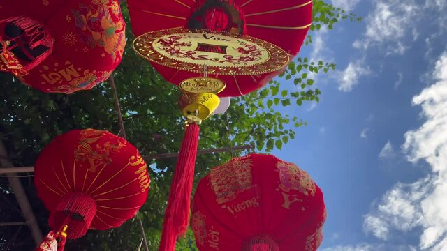 Slowmotion shot of colorful red and golden Chinese lanterns sold on an Asian street market prior to the Tet holiday or Lunar new year in Asia. TET concept. Travel to Asia. Letterings on lanterns and