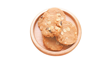 A pile of healthy homemade oat cookies put on a circle wooden plate isolated on a white background..