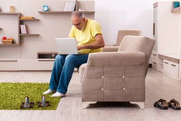 Aged man doing sport exercises at home