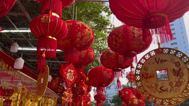 Slowmotion shot of colorful red and golden Chinese lanterns sold on an Asian street market prior to the Tet holiday or Lunar new year in Asia. TET concept. Travel to Asia. Letterings on lanterns and