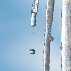 Fototapeta premium water drop from icicle with sky on background