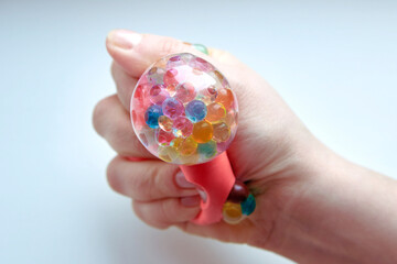Rubber toy antistress in a woman's hand on a white background.