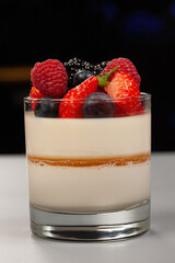 Traditional Italian dessert panna cotta with raspberries, strawberries and other berries
