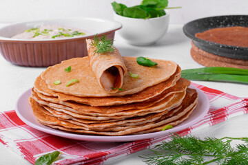 Crepes with rye flour and herring butter served on the white table. Traditional Russian food to celebrate Maslenitsa