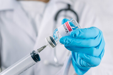 Doctor with a stethoscope holding vaccine syringe of coronavirus