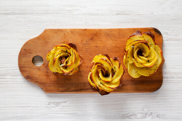 Homemade Potato Roses on a rustic wooden board, top view. Flat lay, overhead, from above.