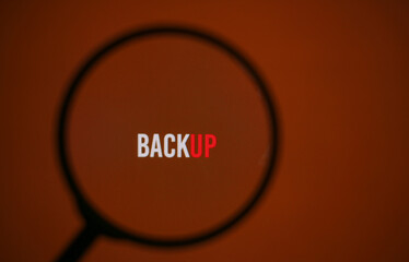 inscription backup on the red screen of the monitor through magnifying glass