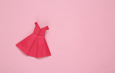 Origami paper red dress on pink background. Copy space