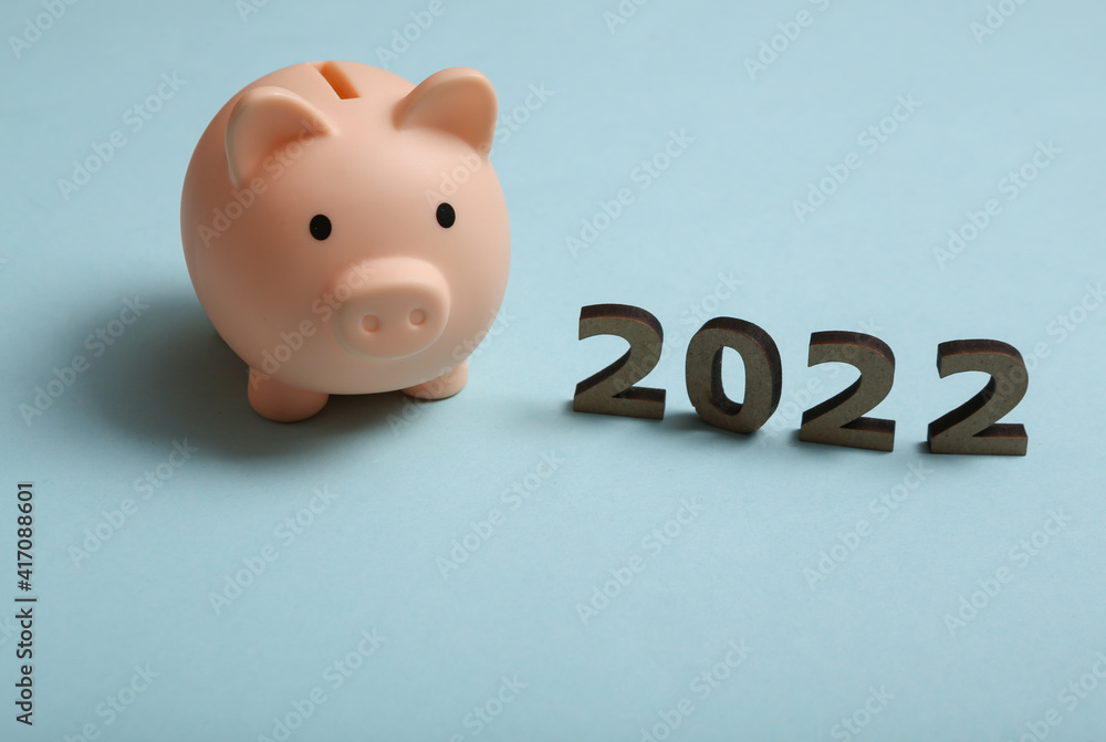 Wall mural 2022 and piggy bank on blue background. economy, new year composition. budget of the year