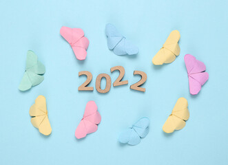 Origami colored butterflies and 2022 on a blue background. Summer 2022