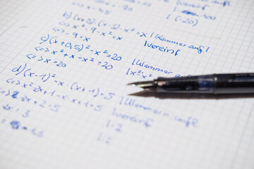 Ein Füller liegt auf einem Hausaufgabenheft mit Matheaufgaben