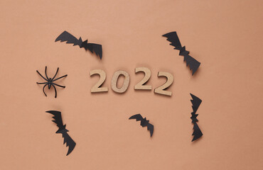 Halloween 2022. Bats, spiders and 2022 on brown background