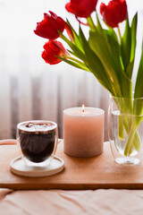 Breakfast: hot coffee and candle standing on the pink bed
