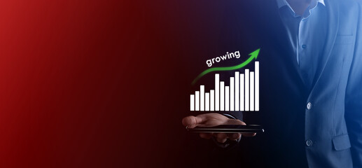 Business man holding holographic graphs and stock market statistics gain profits. Concept of growth planning and business strategy. Display of good economy form digital screen.