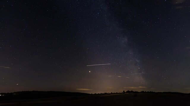 Time lapse landscape with starry sky and planes
