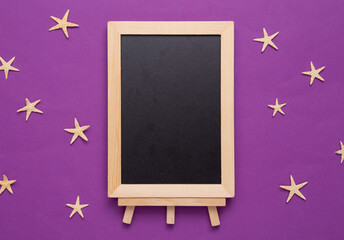 Empty chalk board with starfish on a purple background. Vacation on the beach concept