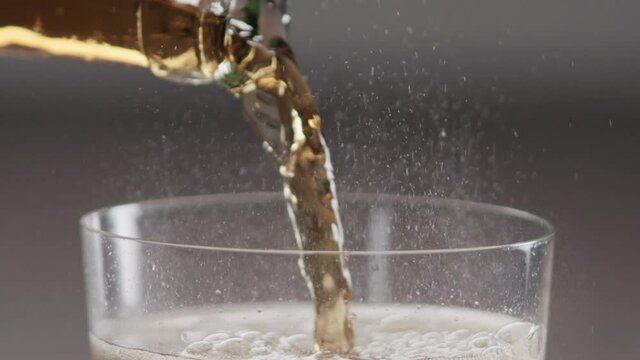 Slow motion pour cold cola into tumbler glass closeup