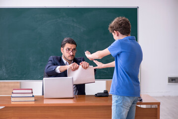 Young male teacher and schoolboy in the classroom