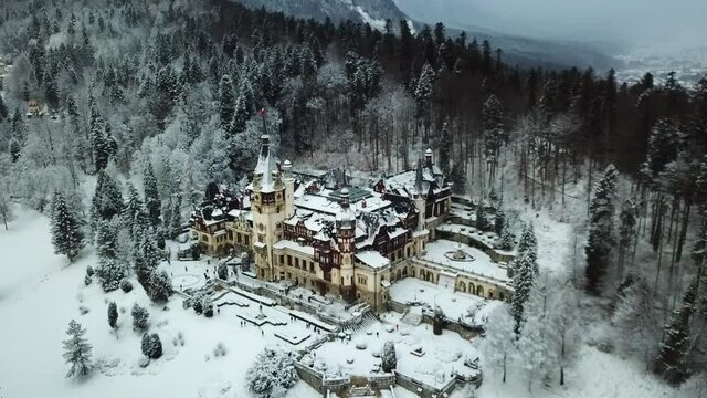 Drone video of Peles Castle in Sinaia during winter. Peles Castle covered in snow panoramic and scenic video.