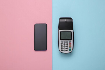 Payment terminal with smartphone on pink blue background. Contactless payment. Top view