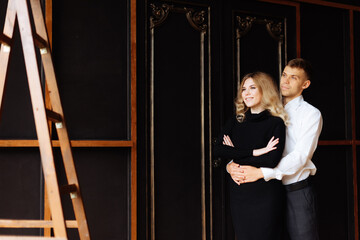 A young man and a woman embrace in a loft-style interior