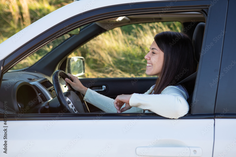 Wall mural young pretty smiling woman driving car