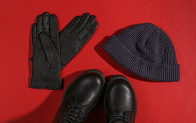 Stylish female leather boots with high soles, hat and gloves on red background with a shadow. Top view