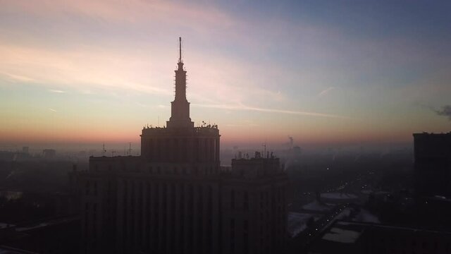 Scenic drone video of Press Building Bucharesc. Casa Presei Bucharest at sunrise with pink sky in the background.