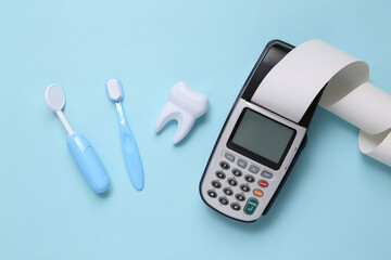 Toy dentist tools, payment terminal on a blue background. Dental care