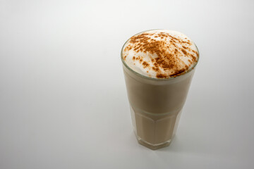 Latte coffee with milky foam sprinkle with cocoa power for decoration in double wall glass isolated on white