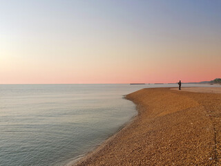 Landscape sea view with beautiful sunset sky and one man stand on beach.