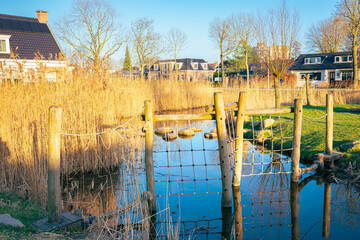 Climbing fence over a small stream in a water playground