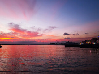 Genova, Italy - February 26, 2021: Beautiful sunset over the sea of Genova in winter days. Amazing red and orange coloured sky reflecting into the water.