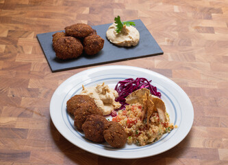 Home cooked arabian food plate, hummus with falafel, couscous and red cabbage