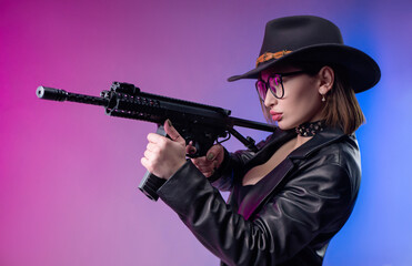 Fototapeta na wymiar a stylish woman in black clothes and a hat poses on a neon background with an airsoft gun