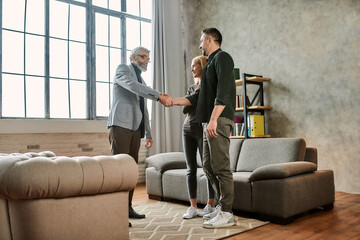 Man shaking hands with psychotherapist next to wife