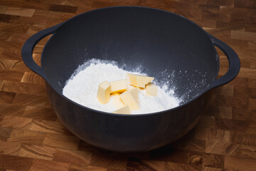 Flour with butter inside a black bowl 