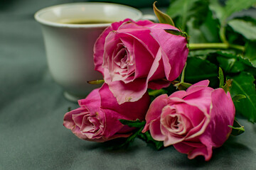 A bouquet of pink roses and a cup of aromatic morning coffee.
