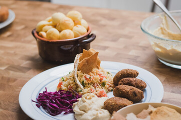 Home cooked arabian food plate, hummus with falafel, couscous and red cabbage