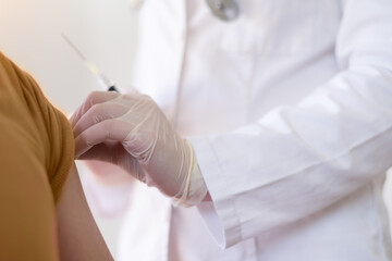Covid vacine injection by doctor at hospital.Doctor making injection vaccination patient to prevent...