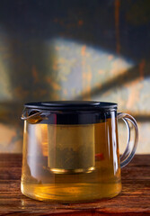 Fruit tea in a glass teapot on a stone background