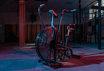 Airbike, professional exercise bike with aerodynamic loading system in red-blue neon light in a...