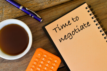 Notebook written with text TIME TO NEGOTIATE over wooden background.
